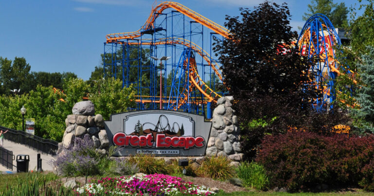 Six Flags Great Escape exterior with rollar coasters and signage 768x403